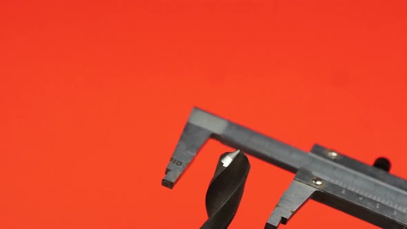 A caliper gauge measures the diameter of a drill. Measuring tool. Measurement accuracy alt