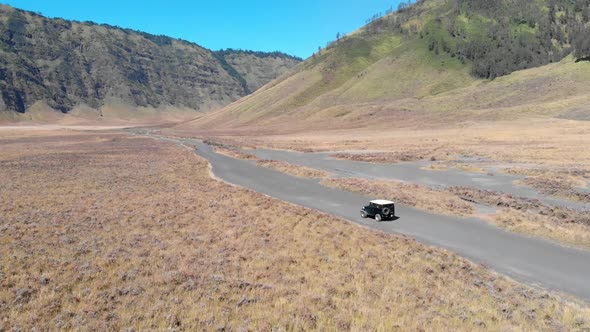 Cinematic aerial video clip of off road car tour cruises on sea of sand desert