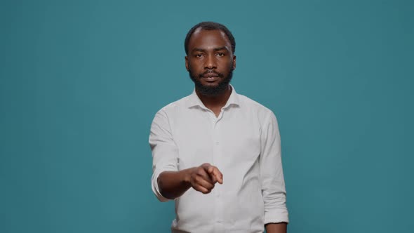 Portrait of Male Model Showing Silence Sign in Front of Camera alt