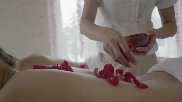 Young beautiful woman in Spa massage salon. Relax treatment with smell of roses flowers. alt