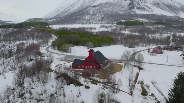 Red church in Olderdalen, Norway. Overcast winter weather.4K aerial drone shot with a slow sideways alt