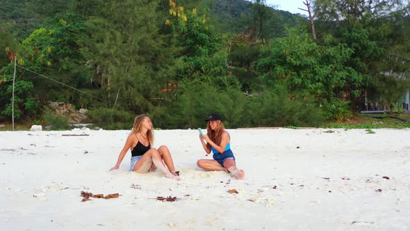 Ladies together tanning on marine lagoon beach wildlife by shallow ocean with white sand background  alt