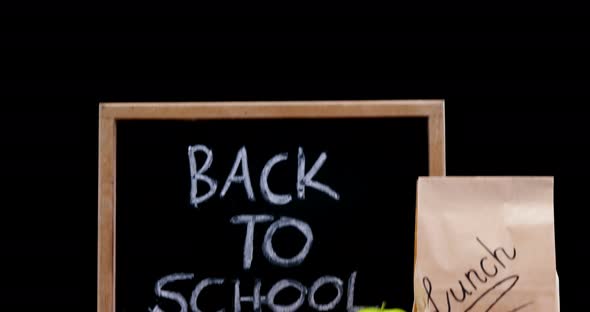 Slate, apple and paper bag on table alt