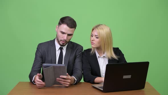Young Business Couple Using Digital Tablet and Laptop Together
