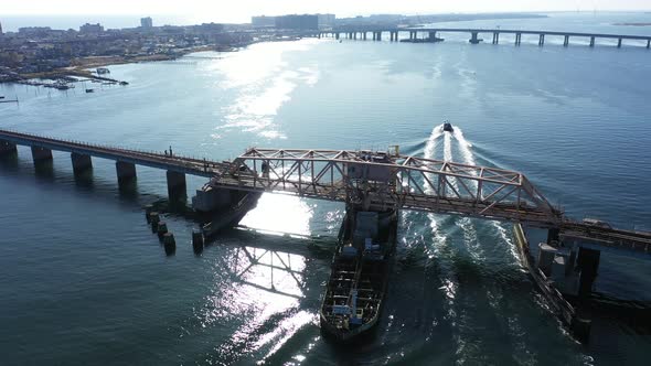 An aerial shot of a swing bridge over s bay in Queens, NY. The camera trucks right & boom up as the alt