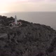 Aerial reverse, drone shot tilting away from the Far des Cap Gros lighthouse - VideoHive Item for Sale