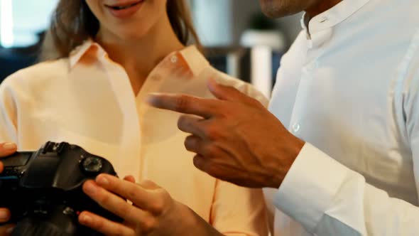 Graphic designers discussing over digital camera alt