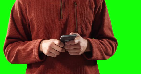 Caucasian man using a smartphone on green background