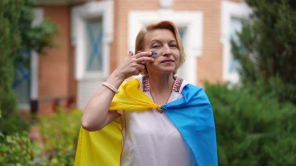 Medium Shot Portrait of Proud Ukrainian Woman Wrapped in National Flag Drawing Blue and Yellow on alt