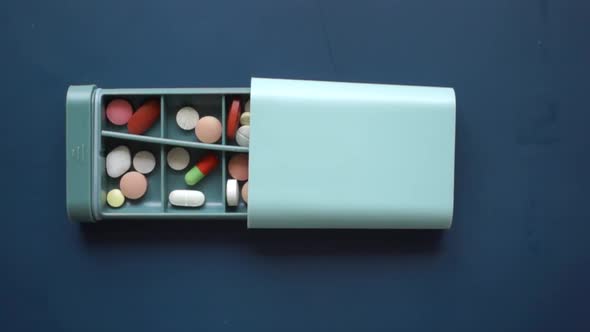 Close Up of Medical Pills in a Pill Box on Table alt