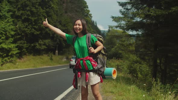 Lovely Asian Woman Backpacker Travelling By Autostop on Summer Vacations alt