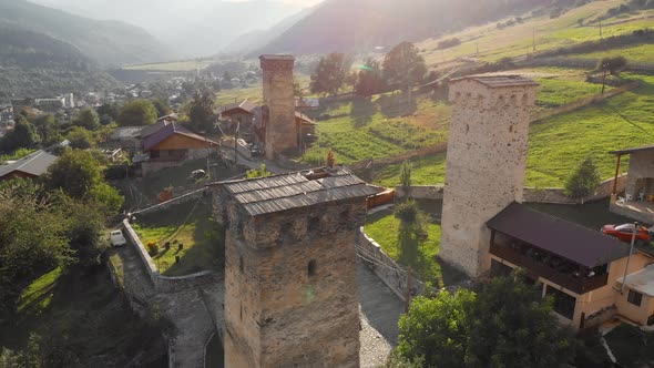 Woman Sits on the Roof of a Svan Tower at Sunset in Mestia Georgia alt