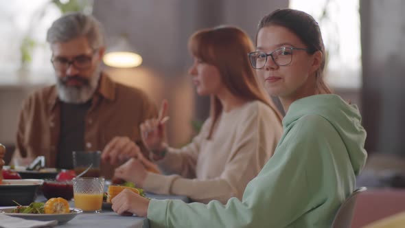 Portrait of Cheerful Teen Girl at Family Dinner alt