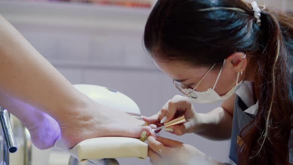 Cosmetologist Performs the Procedure Makes Brush Strokes Applies Varnish Processes the Client's Nail alt