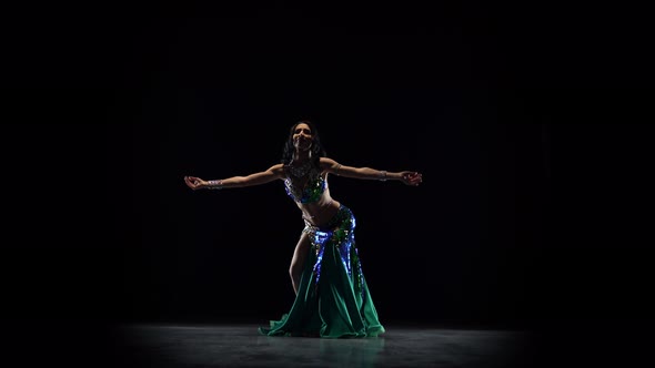 Attractive Girl Performing a Belly Dance, Black Background alt