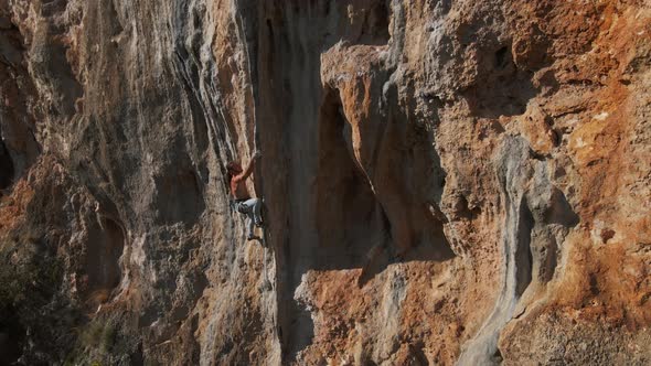 Slow Motion Aerial Drone Footage of Strong Man Rockclimber Climbing Up on Tough Hard Route on alt