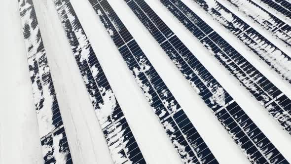 Aerial View of a Snow on Solar Panels Farm in Winter alt