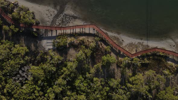 A static drone video of a secret timber boardwalk winding through a coastal conservation wetland alt