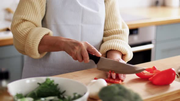 Hands of Woman Chopping Pepper on Kitchen