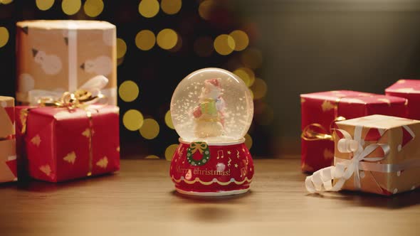 Christmas Snowglobe and Christmas Gifts on Table