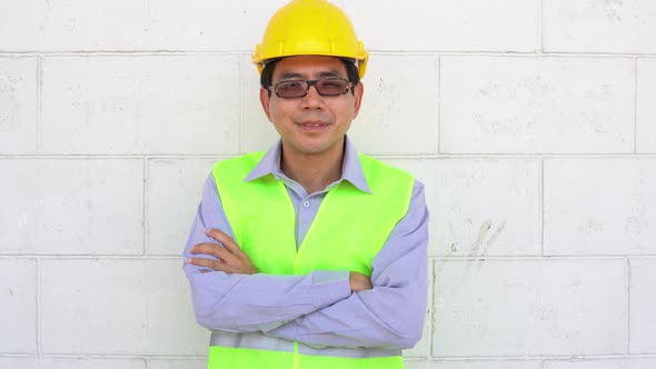 Asian male worker smiling and looking at camera