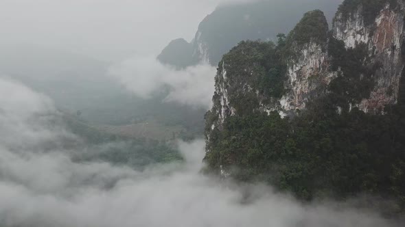 Flying Above the Clouds Near the Big Green Mountains During the Rain in Thailand