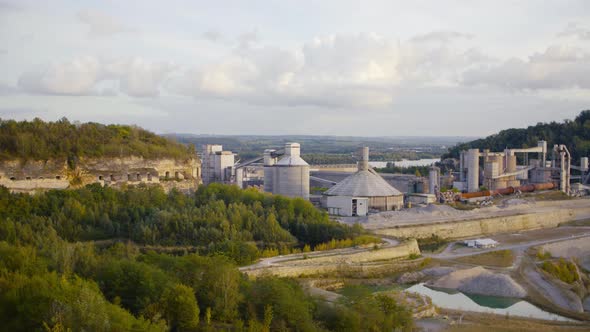 A panoramashot of a quarry surrounded by trees and mountains with a hidden defense fortress in a clo alt