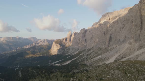 Sunlit Dolomites Mountains peaks, barren rock massif, panoramic aerial view alt