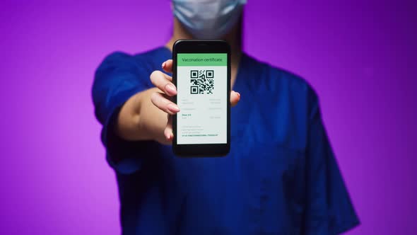 Woman Surgeon in Medical Uniform Showing Vaccination Passport with Qr Code on Phone International alt