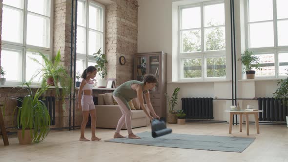 Fit Mother and Cute Daughter Practicing Yoga alt