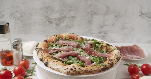 Delicious Pizza with Prosciutto Parma Ham Arugula Salad Rocket with Ingredients alt