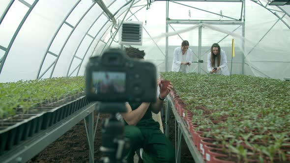 Young Farmer Recording Video in a Greenhouse