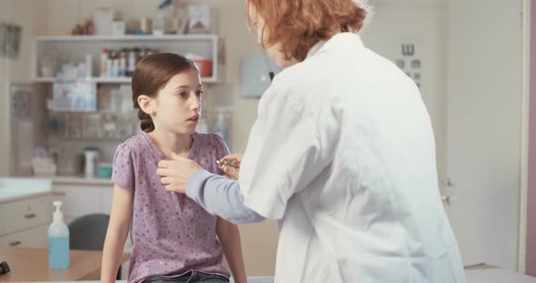Female doctor checking a young girl in the clinic alt