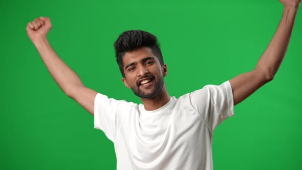 Excited Handsome Middle Eastern Football Player Gesturing Victory Posing on Green Screen alt
