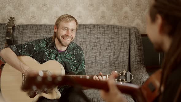Cheerful Man Playing Guitar with Friend