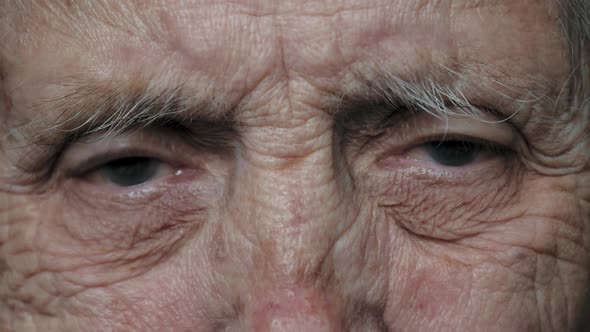 Close Up Of Eyes Of An Old Elderly Woman With Deep Wrinkles And A Nervous Tic alt