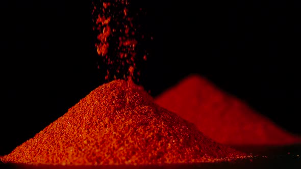 SLOW MOTION: Red Pepper Powder Pouring On A Table - Close Up alt