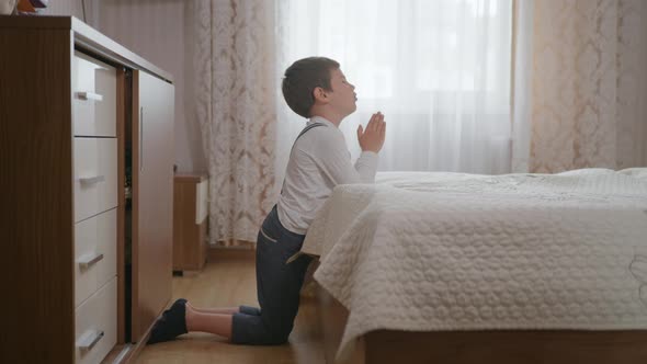 Religion, Little Christian Boy with Faith and Hope in Heart with Closed Eyes Clasped Hands Prays To alt