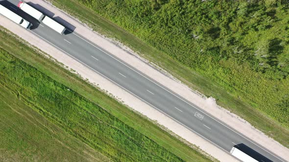 Aerial view of a fast trucks on the road in countryside. 