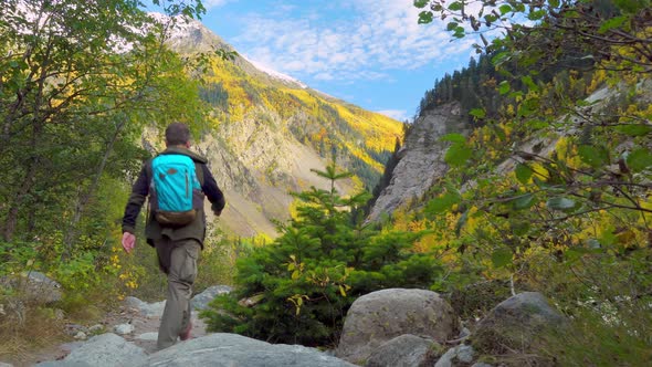 A couple of young men with backpacks alone in the autumn mountains. alt