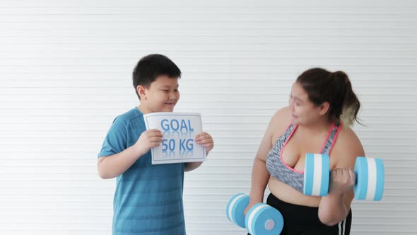 Mother obesity workout with stretching and Son encouraging at home