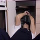 A Male Plumber Repairs Pipes or a Drain Siphon Under the Sink in the Kitchen - VideoHive Item for Sale