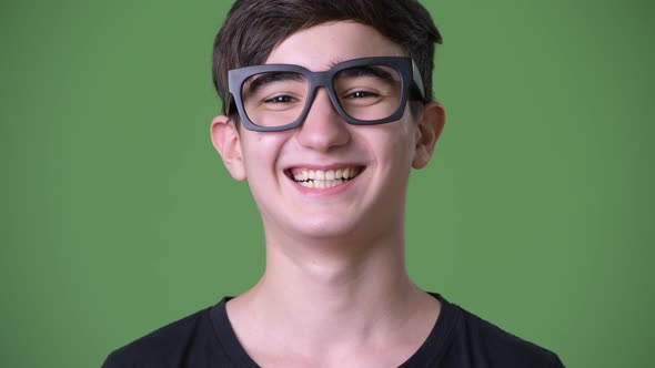 Young Handsome Iranian Teenage Boy Against Green Background alt