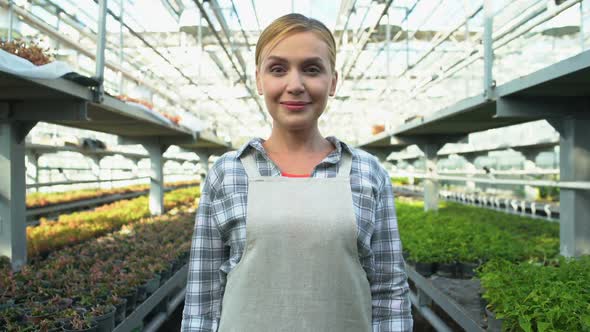 Successful Female Farmer Crossing Arms on Chest and Smiling in Greenhouse