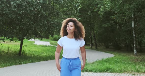 Relaxed Mixed Race Curly Young Modern Female Walking at Summer Forest Park Spending Time Outdoor alt