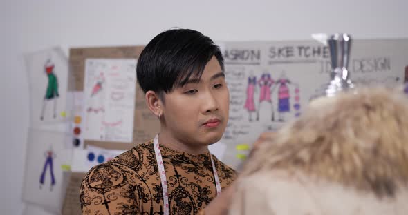 Professional fashion designer man checking mannequin model alt