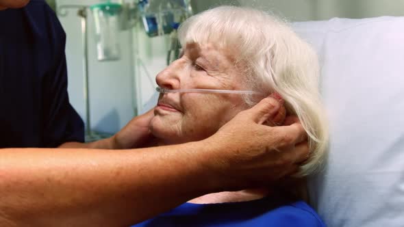 Nurse examining a senior patient in the ward 4k alt