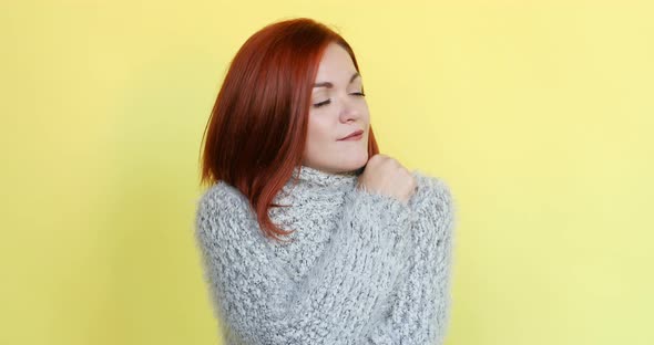 Red Haired Woman in Gray Sweater Embracing Herself Dreaming About Warm in Cold Winter Night