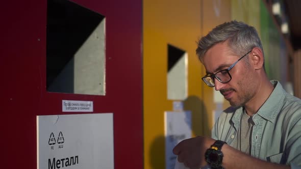 Man Disposes of Metal Waste and Throws It Into Wall Bin Stands on Street Spbd alt
