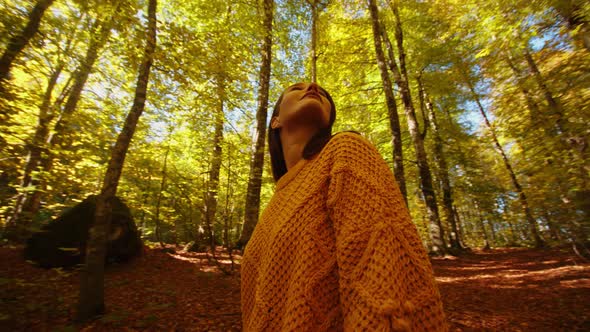 Closeup of Young Woman Looking Up to the Tree Crowns in the Fall Forest